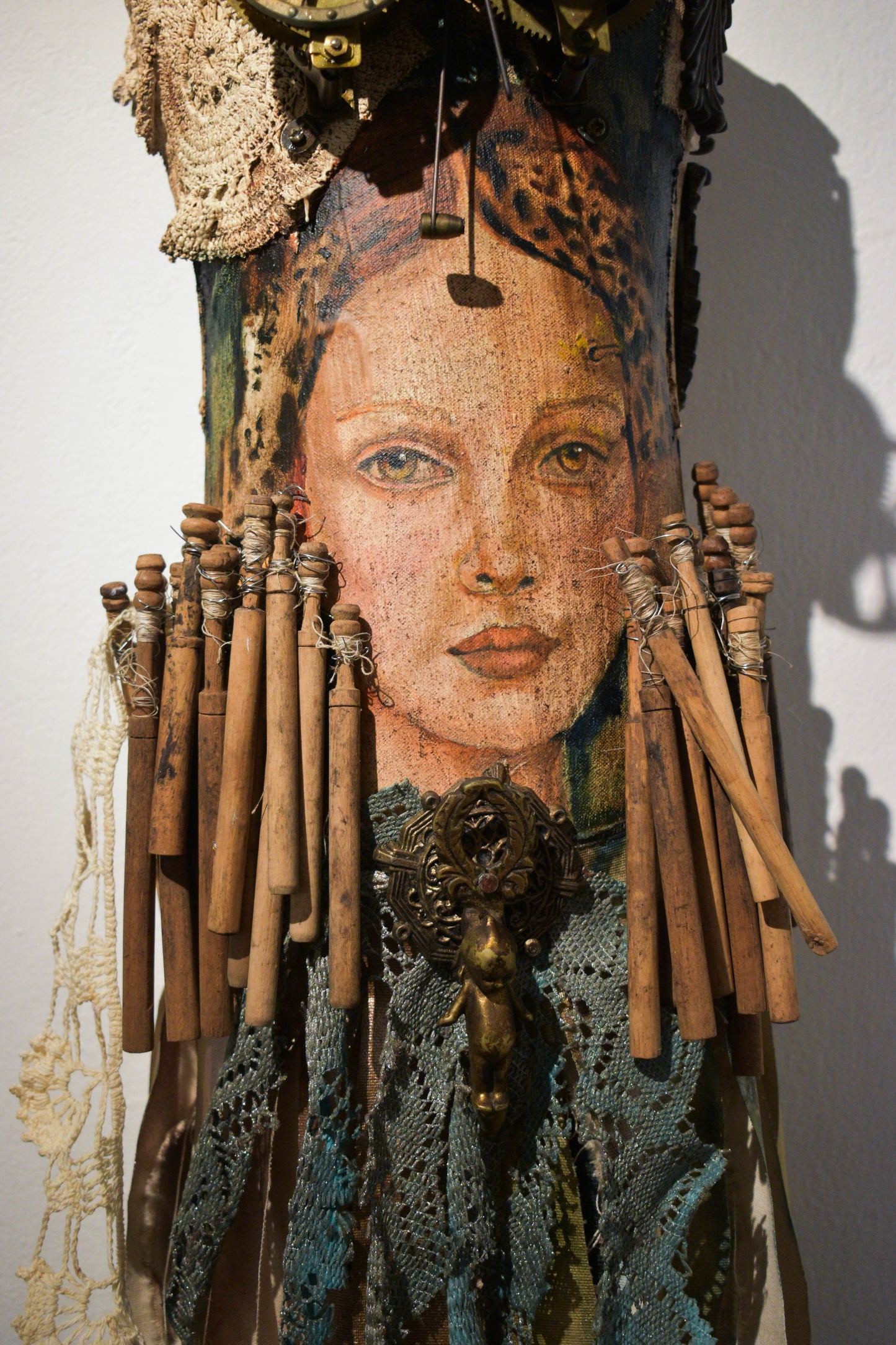 Artistic sculpture with a woman face, lace, and wooden elements