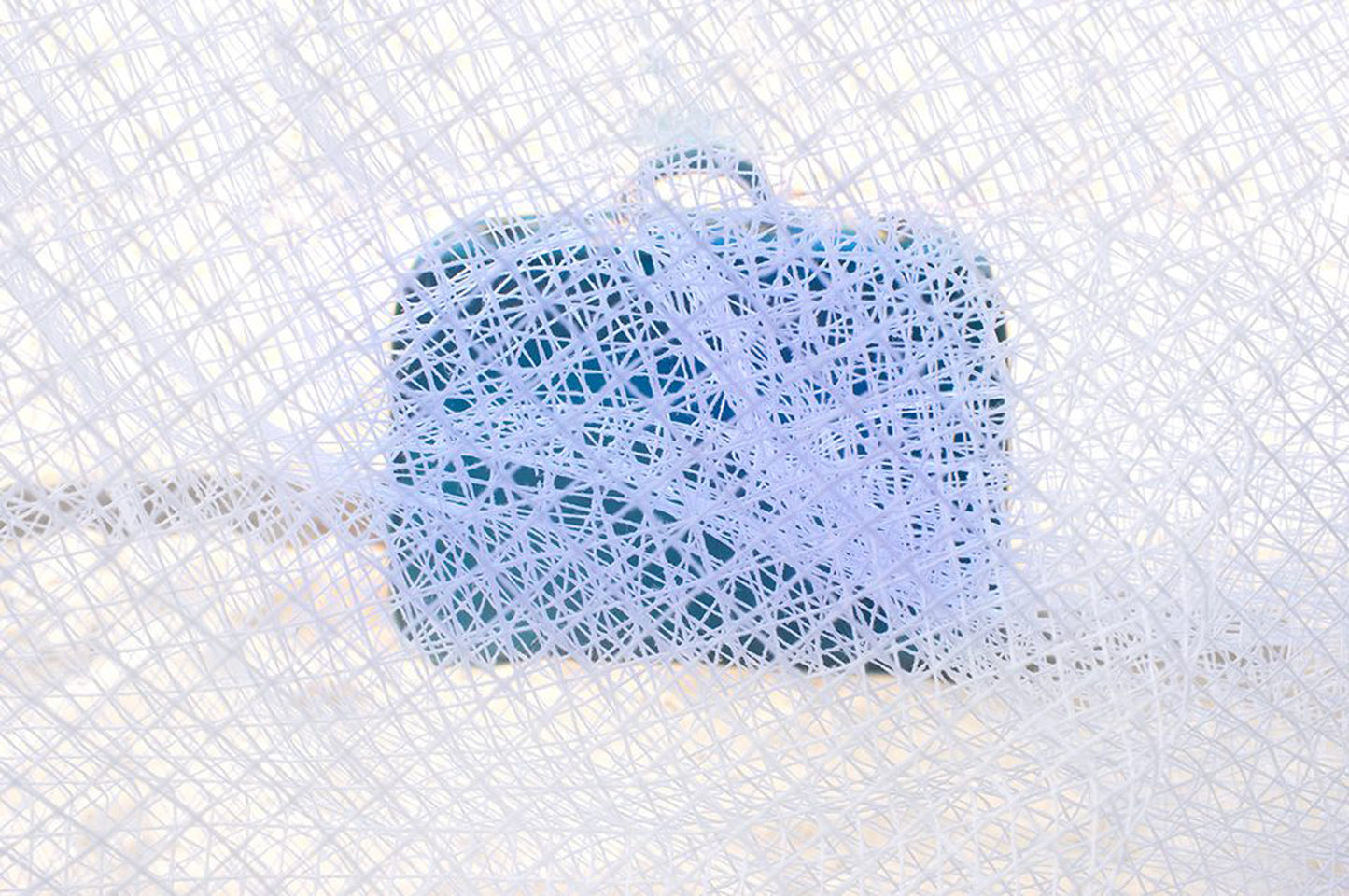 A blue suitcase with a textured, dotted pattern in front
