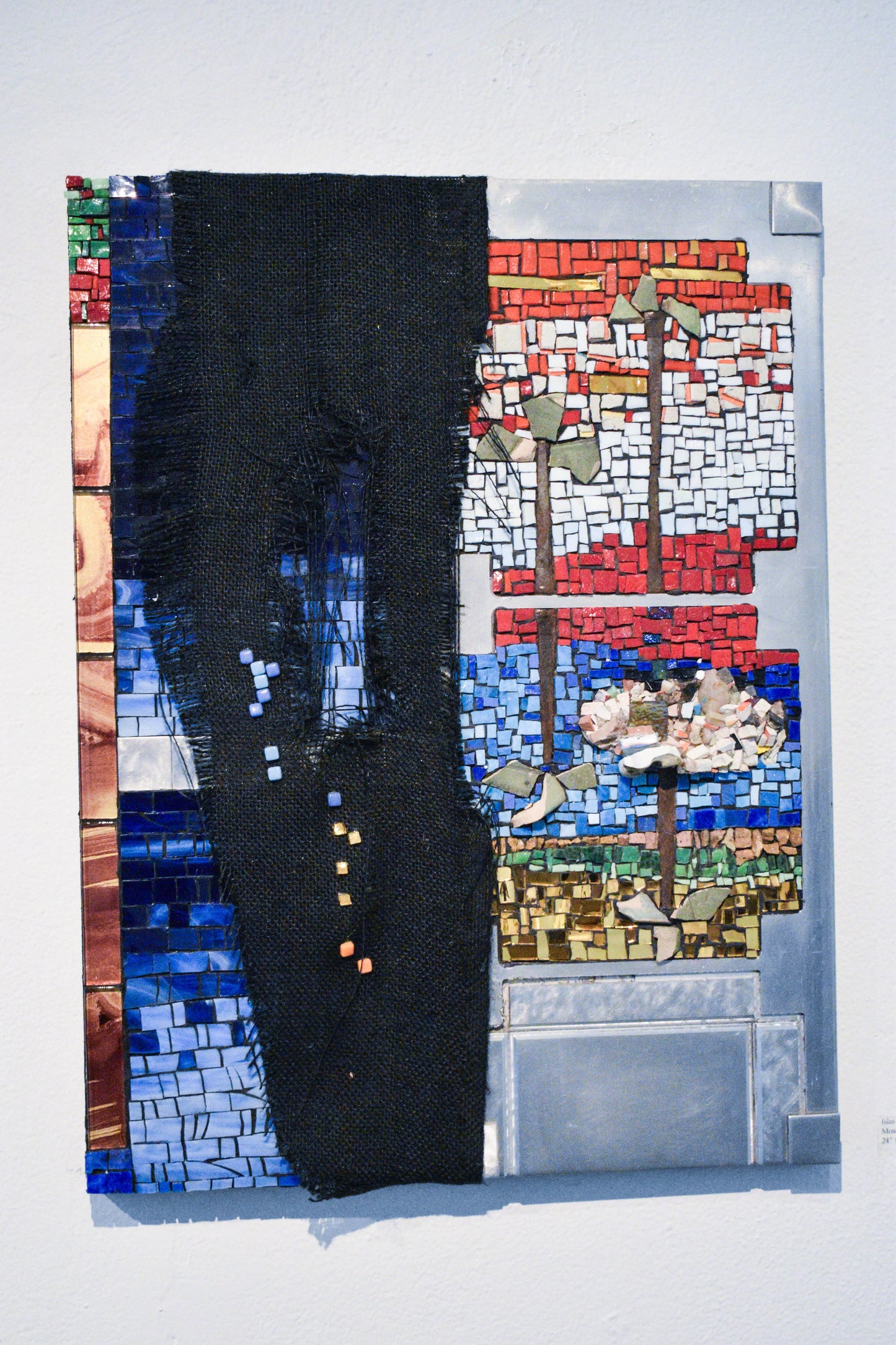 Mosaic with abstract patterns and a black textile strip.