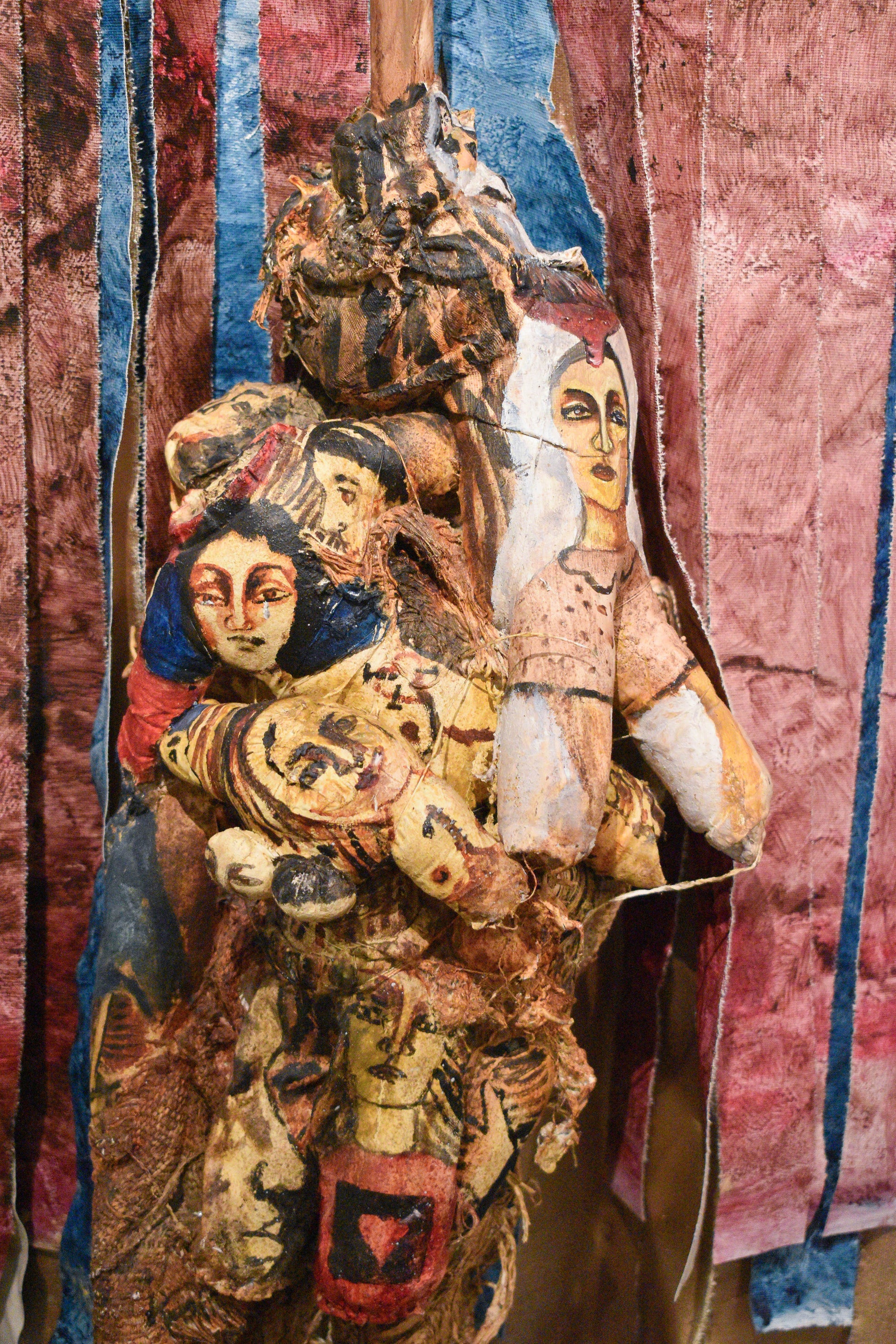 Decorative textile with embroidered figures and patterns on a textured background