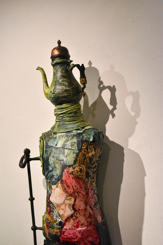 Mixed media object sculpture with painted elements and an attached teapot.