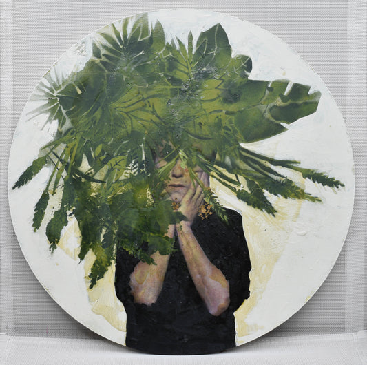 Circular format mixed media artwork of child holding their face with leaves on front