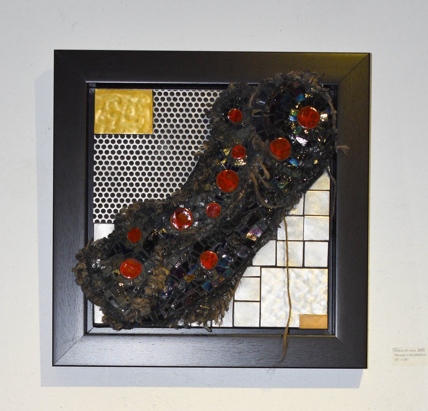 Framed mosaic artwork with textured material and red circular elements.
